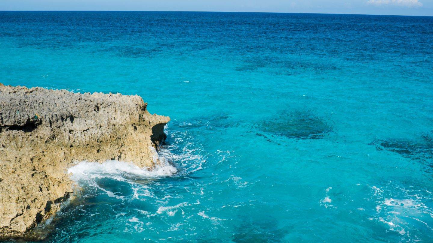 Turquoise surf working against a limestone point on the ocean side