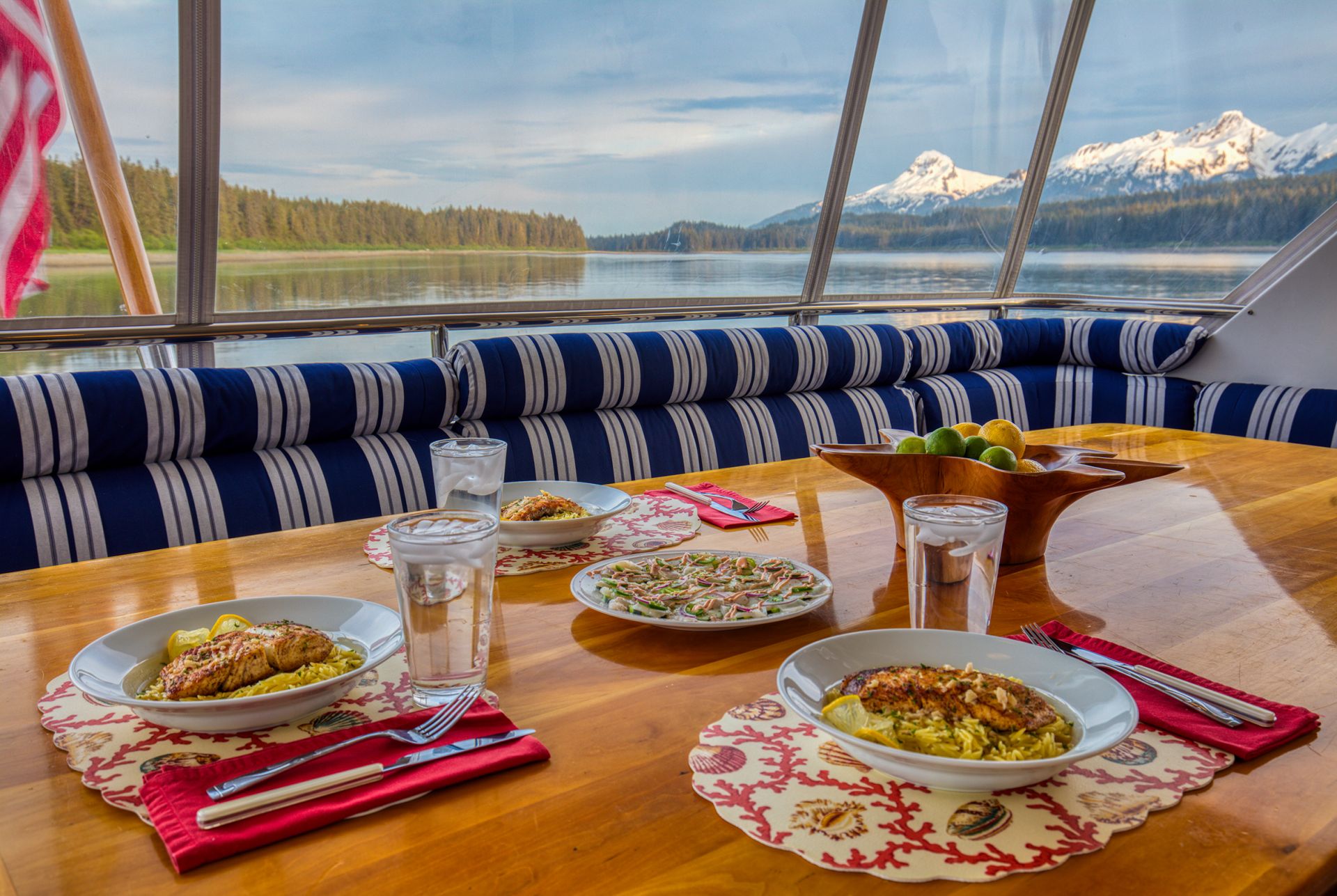 The chef working fresh salmon in the galley, fjord light through the windows.