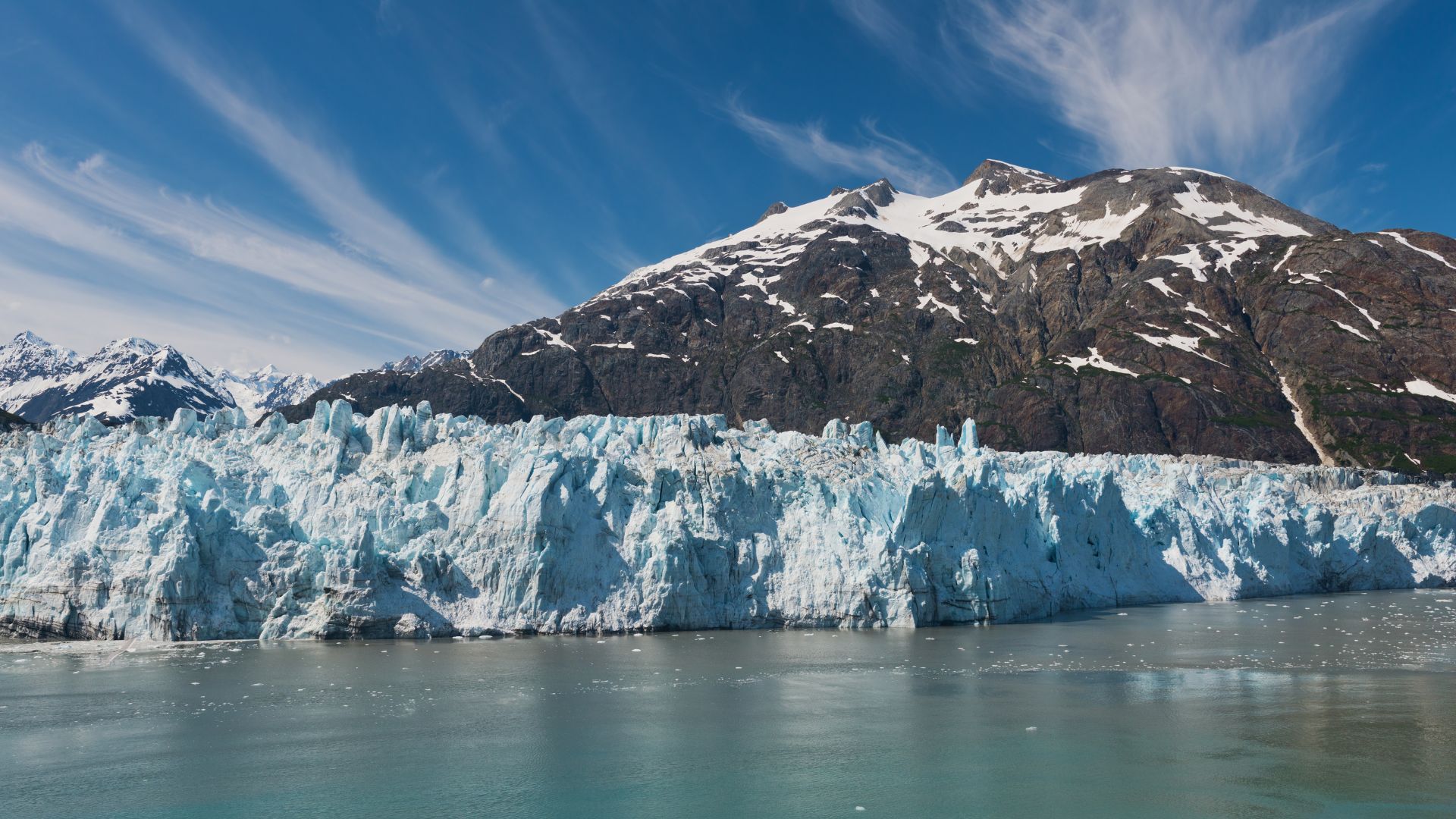 The white-and-blue calving face of Margerie Glacier towering over the water in Glacier Bay