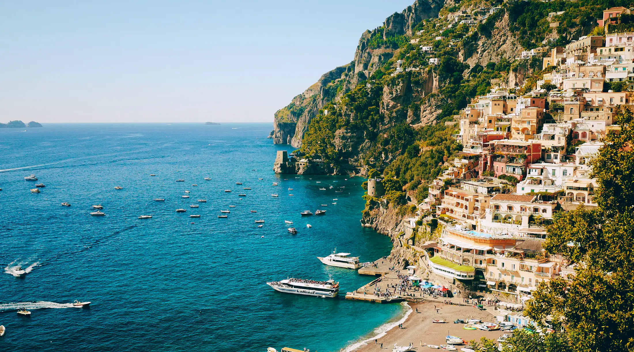 Positano from above — the pastel cliffside town tumbling to Spiaggia Grande and the Tyrrhenian.