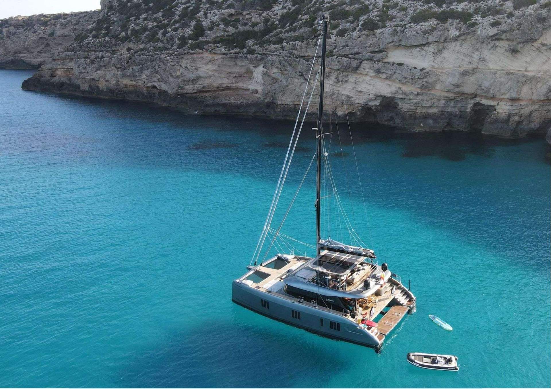 Crewed yacht at the Port de Cabrera anchorage with the medieval watchtower on the headland