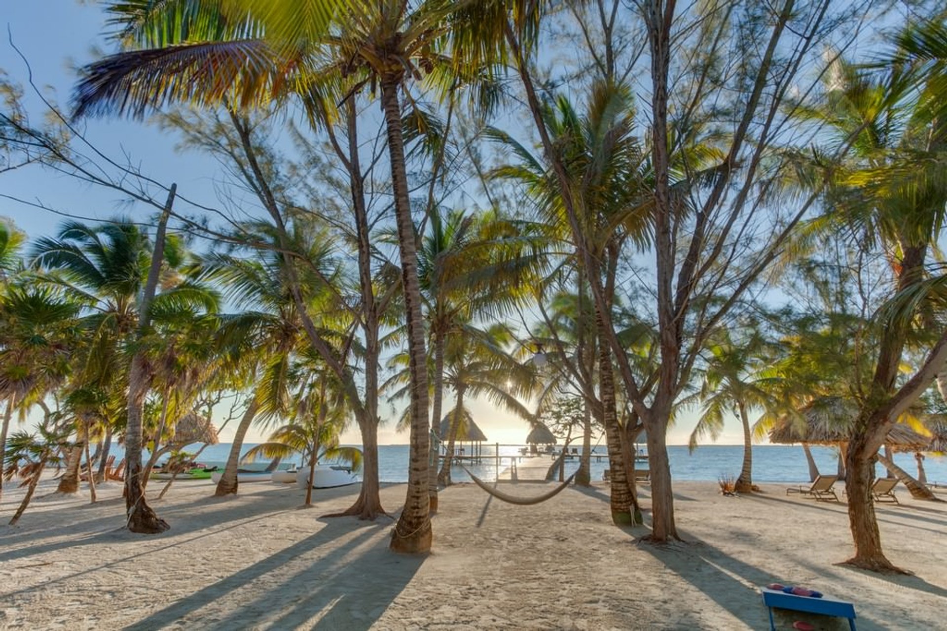 Coco Plum Caye on the inside of the Belize Barrier Reef—palm-fringed sand, thatched roofs, clear shallows.