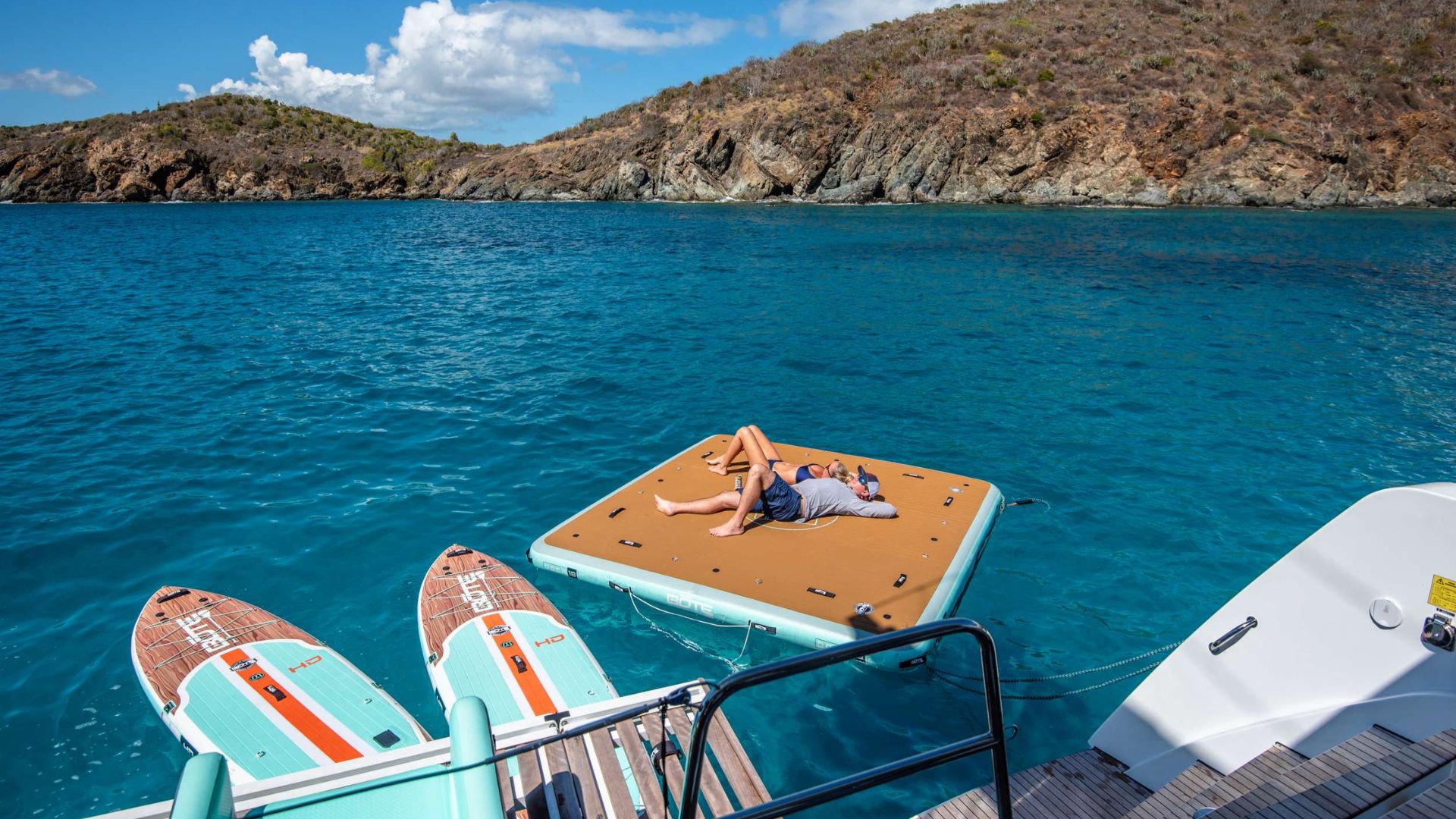 Couple relaxing on a floating mat in a secluded turquoise cove in the British Virgin Islands