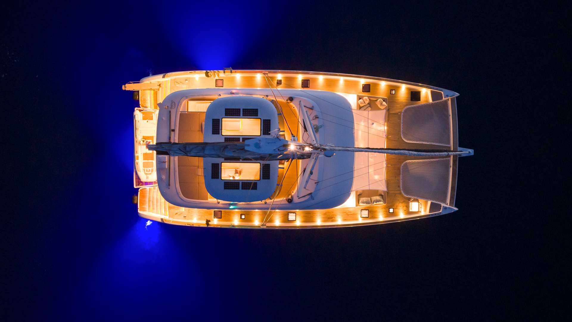 Crewed catamaran lit up at anchor at night, Dalmatian Coast