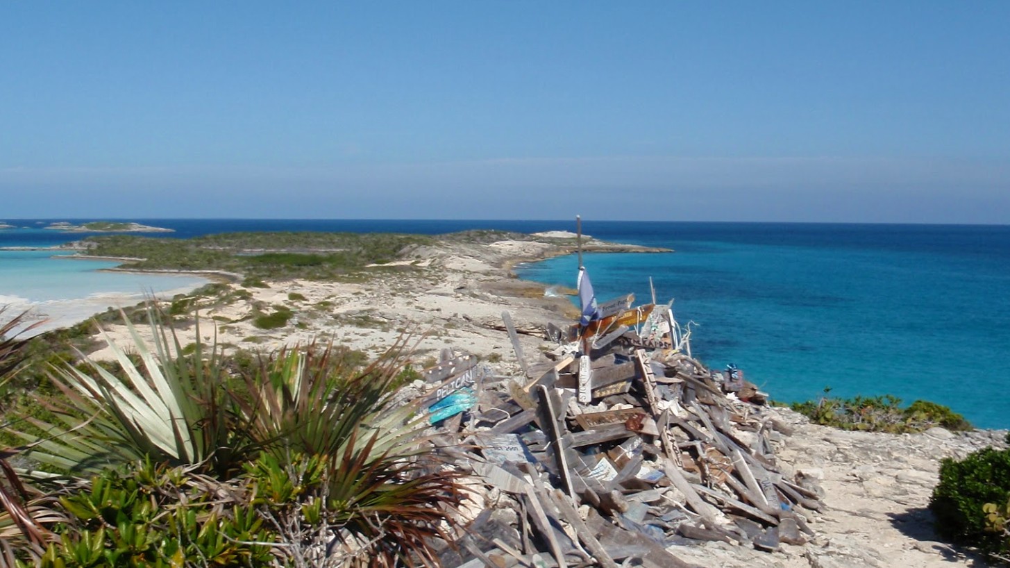 The driftwood-sign pile at the top of Boo Boo Hill — every boat that has ever taken a mooring here leaves one.