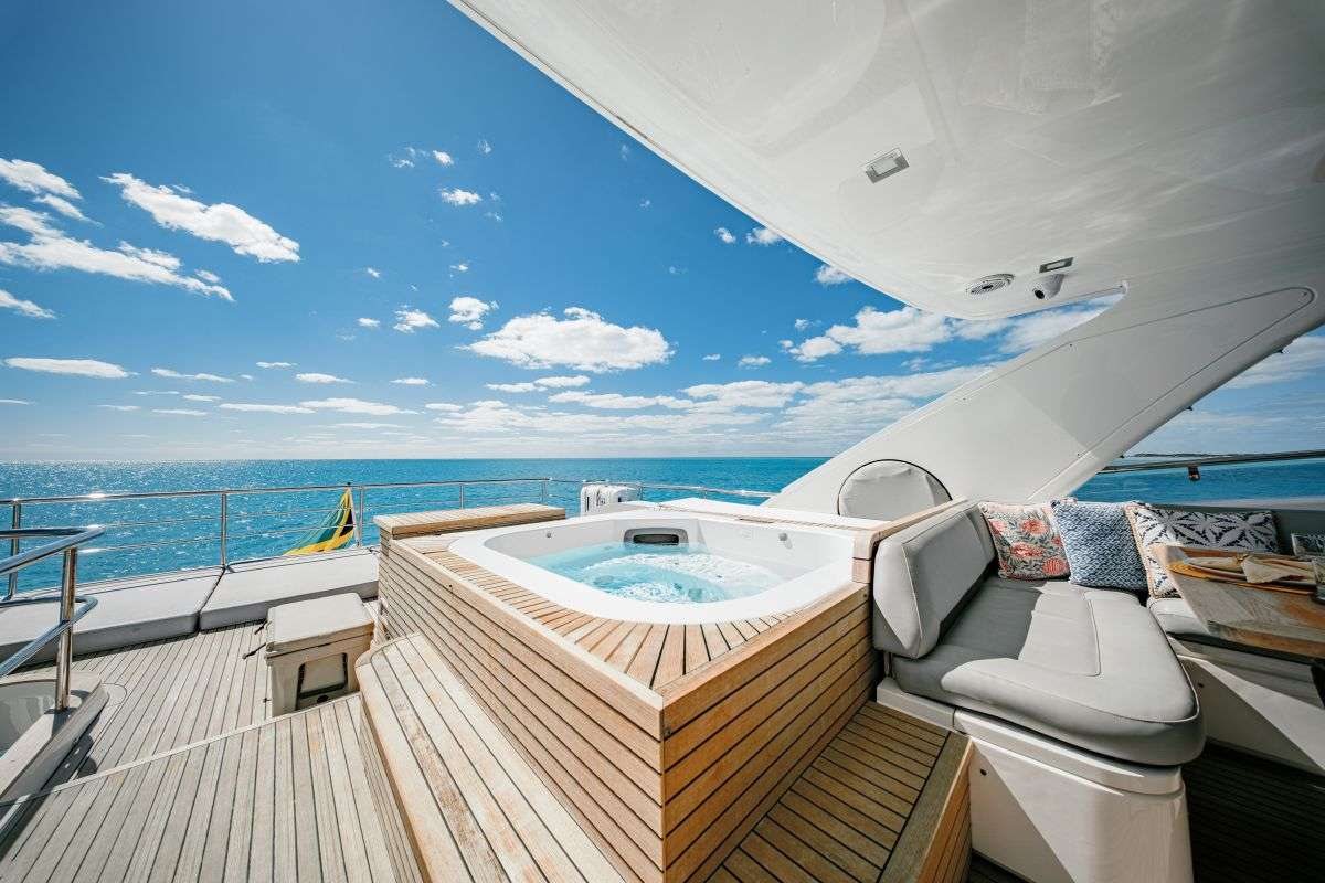 The afternoon is for the yacht itself — the flybridge and the jacuzzi at a quiet anchorage.