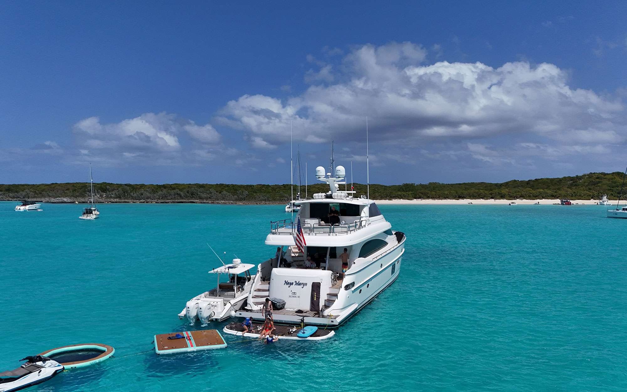A motor yacht anchored off Big Major Cay, toys out, the pig beach just ashore.