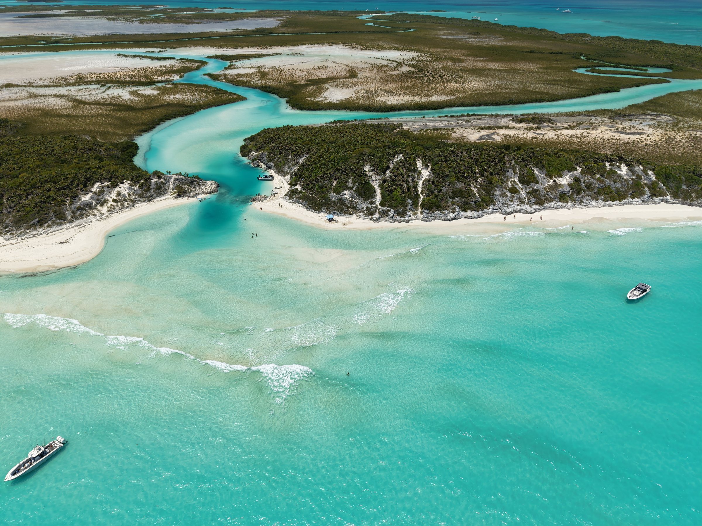 The creek opens onto the ocean side, where the crew sets up a beach day off the tenders.