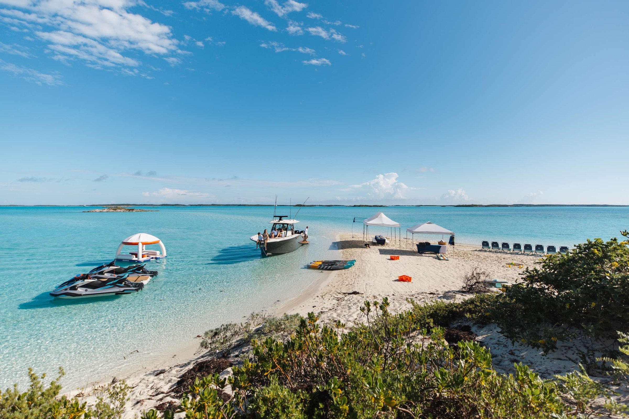 The crew runs the tenders out and sets up the day on a private sandbar: shade, loungers, and lunch.