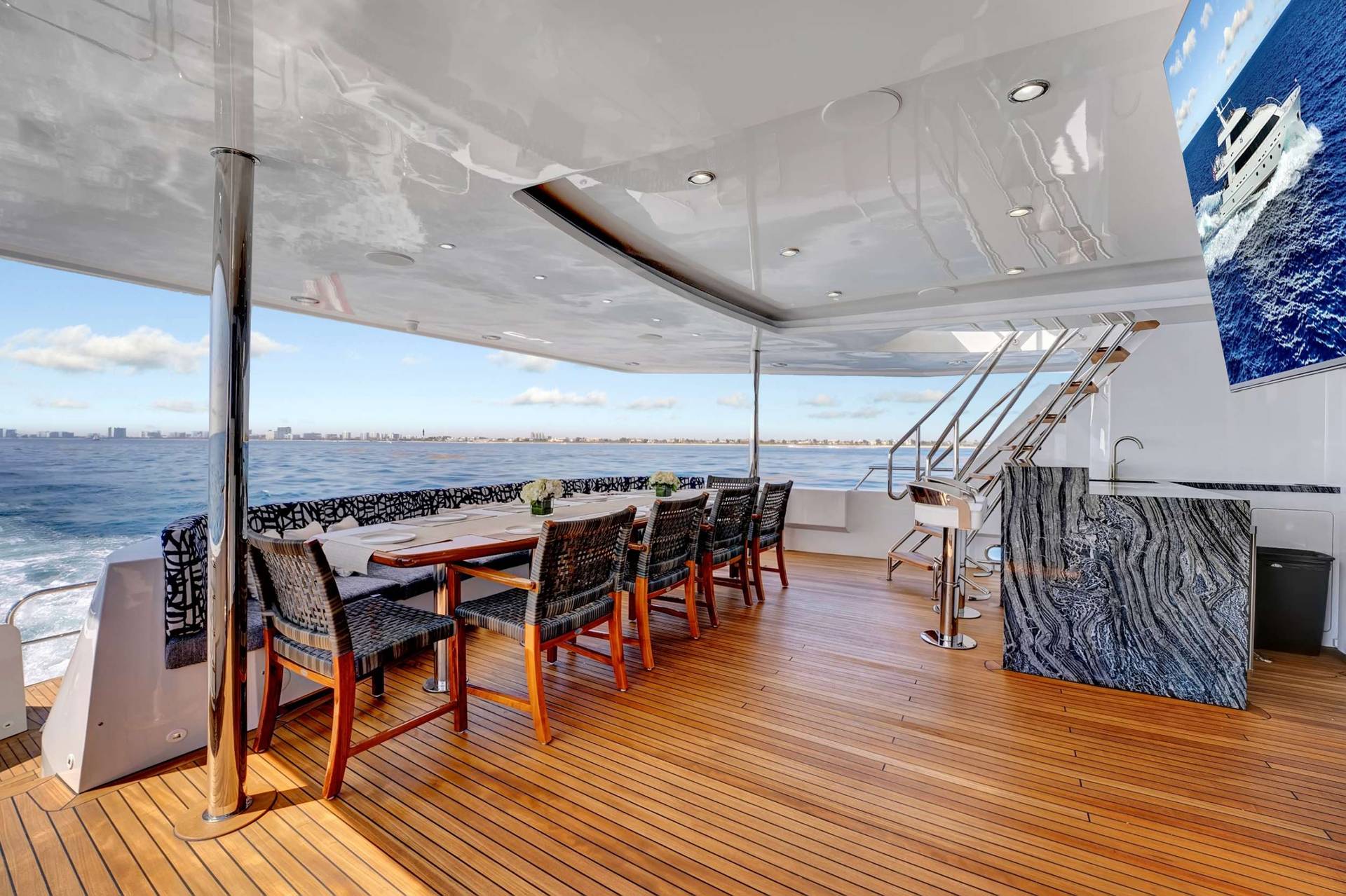 Aft-deck dining table set aboard a motor yacht running the South Florida coast