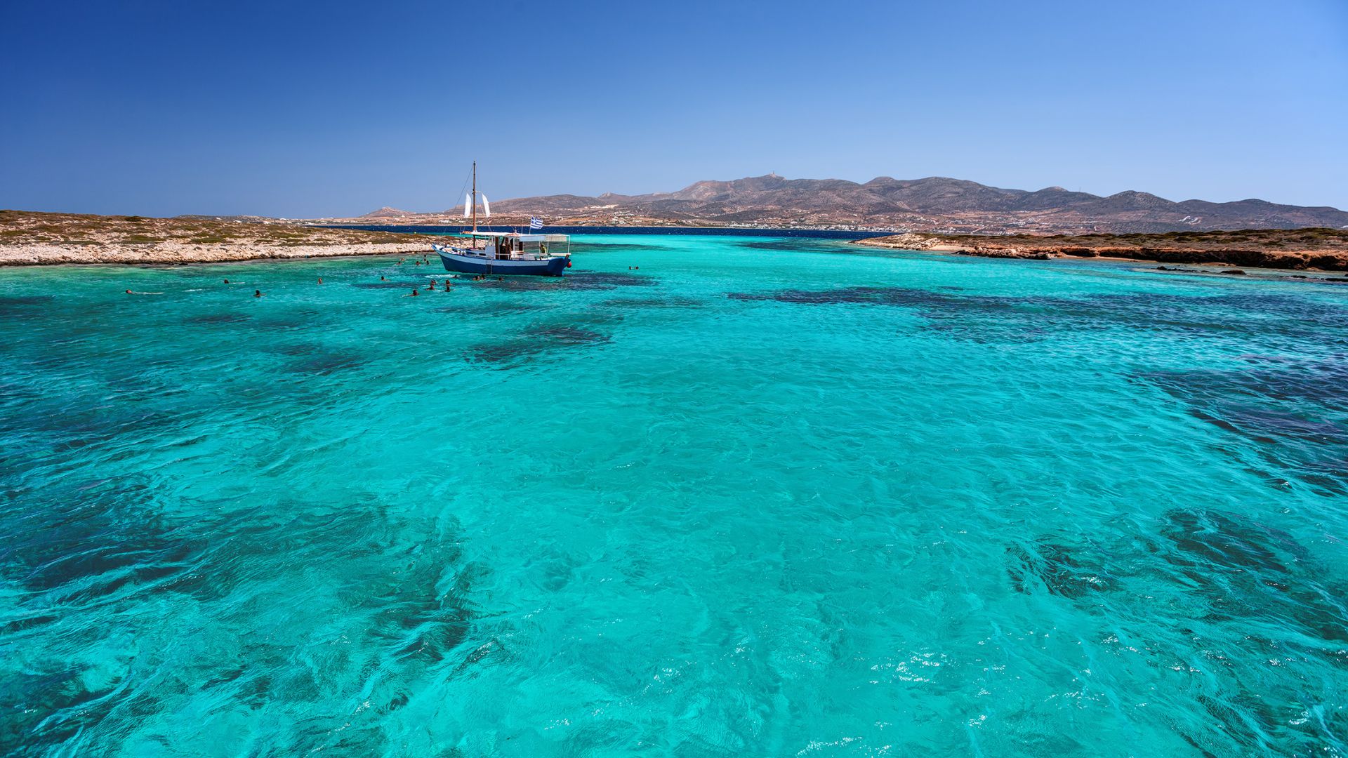 The Blue Lagoon between Antiparos and the uninhabited islet of Despotiko—shallow, electric turquoise, and one of the clearest swim stops on the route.