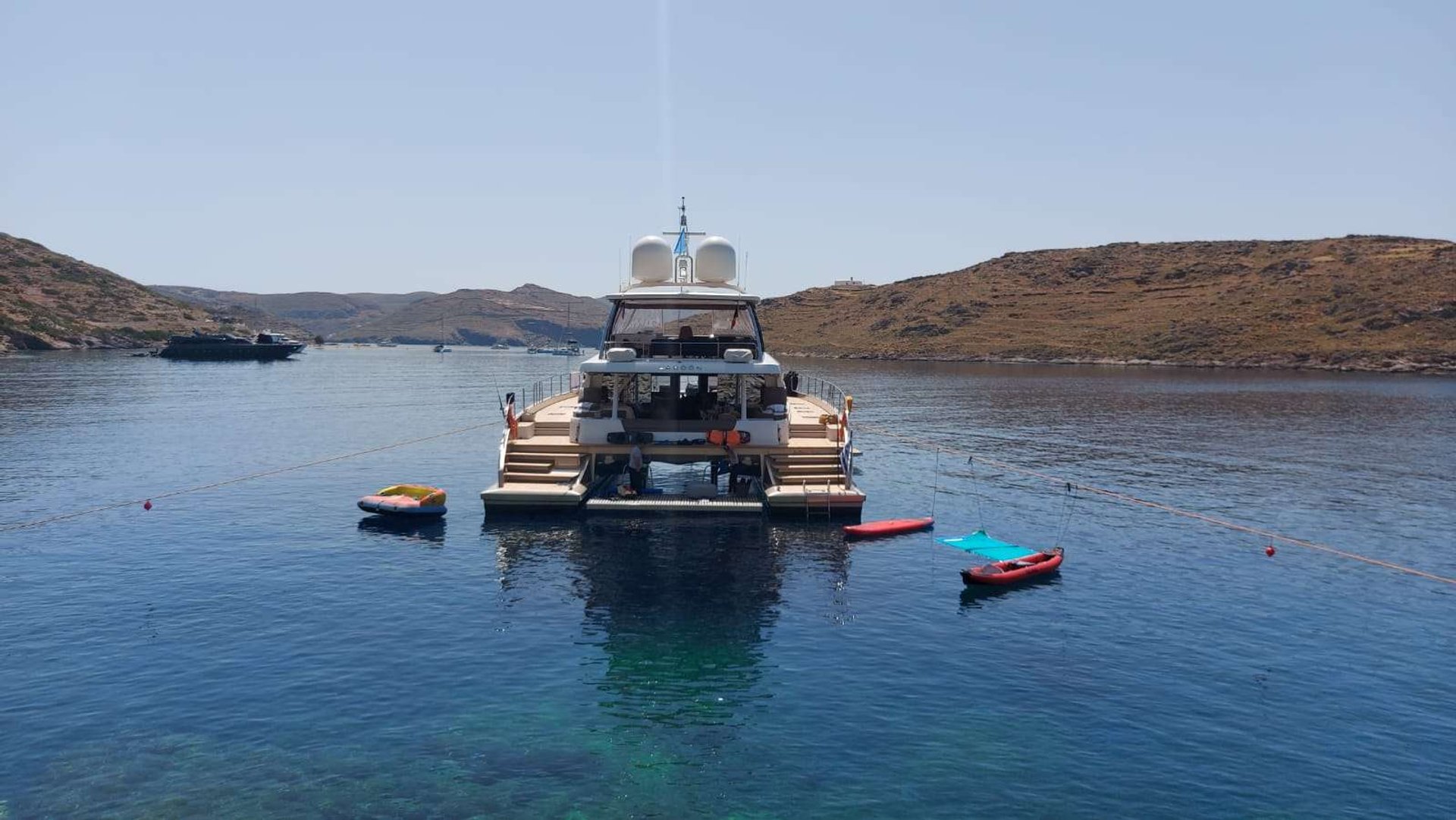 Crewed yacht in a Greek cove with water toys deployed