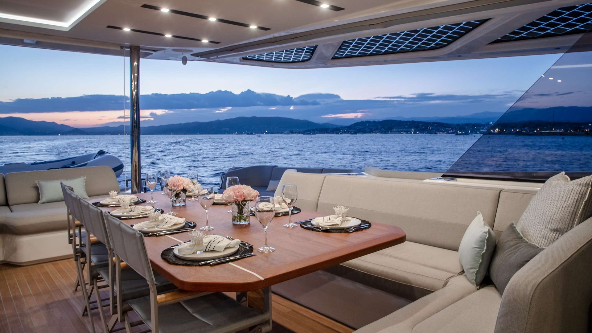 Aft-deck dinner aboard a crewed yacht in Greece at sunset