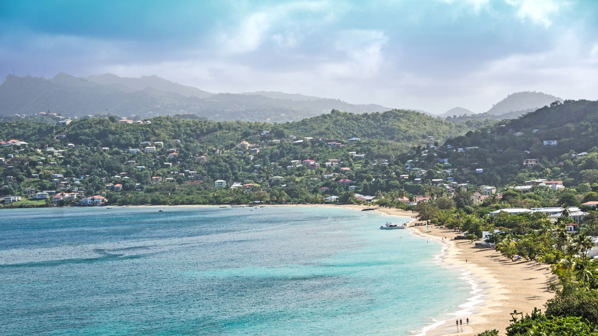 Grand Anse — a long curve of pale sand and calm water below the green hills just south of St. George's, one of the great swimming beaches in the region.