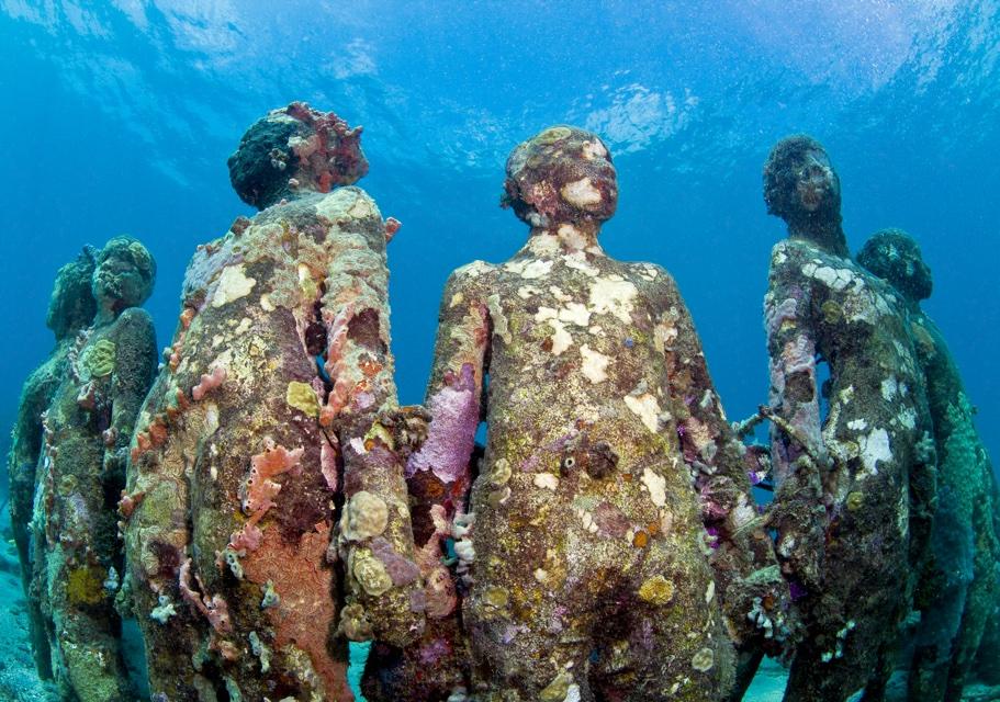 Molinère, off Grenada's west coast — the world's first underwater sculpture park, the cast figures now thick with coral and sponge. You snorkel it straight off the boat.