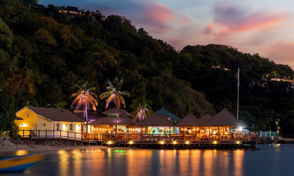 Basil's Bar at Britannia Bay—open-air, on stilts, the most famous beach bar in the Caribbean. Mick Jagger funded the rebuild after Hurricane Beryl flattened it in 2024.