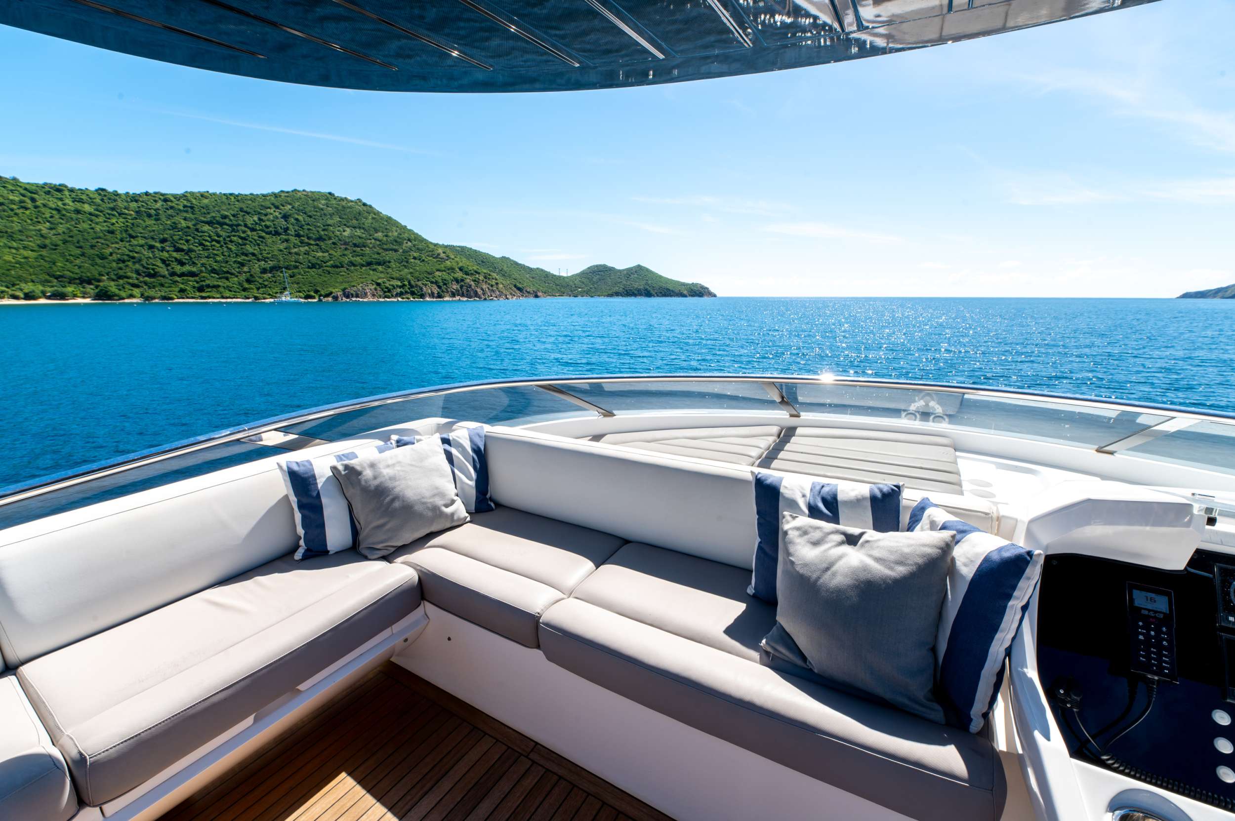 Bow lounge open at anchor off Canouan's leeward coast—the trades blocked by the headland, the boat barely moving on its chain.