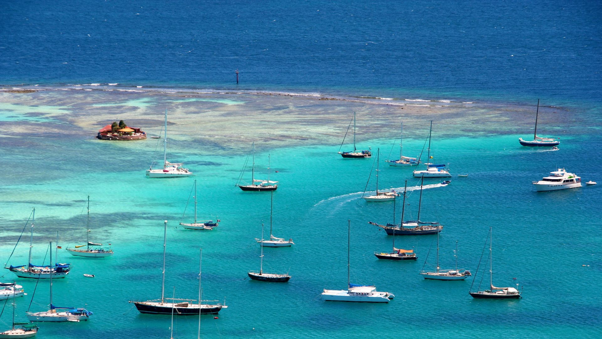 Clifton harbor on Union Island. The small red structure on the reef in the upper left is Happy Island—a bar built by Janti Ramage on a man-made island of conch shells he piled up himself, one bag at a time.