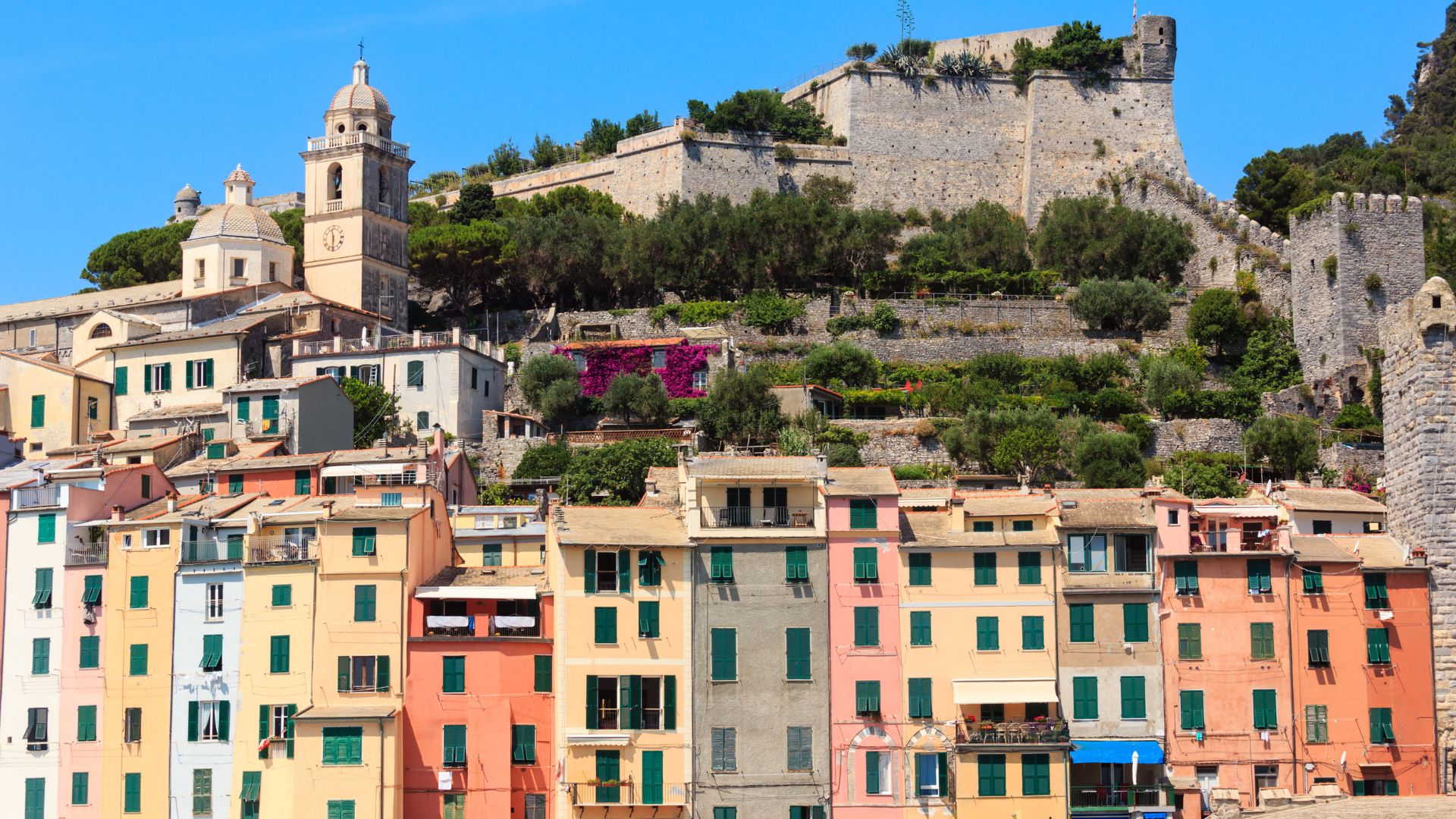 Portovenere's painted houses and Church of San Pietro on the rocky point at the harbor mouth.