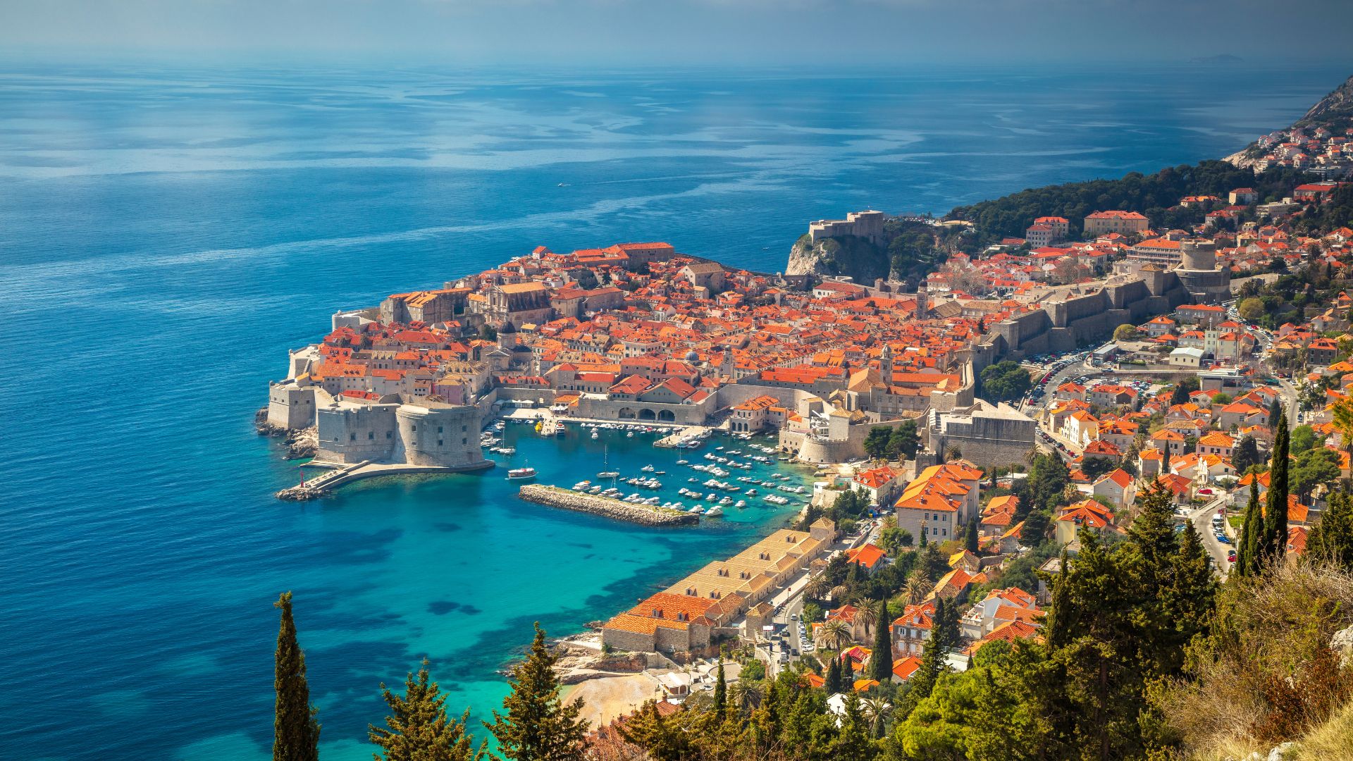 Dubrovnik's Old Town from above — fortified walls, terracotta roofs, the old harbor visible on the right.