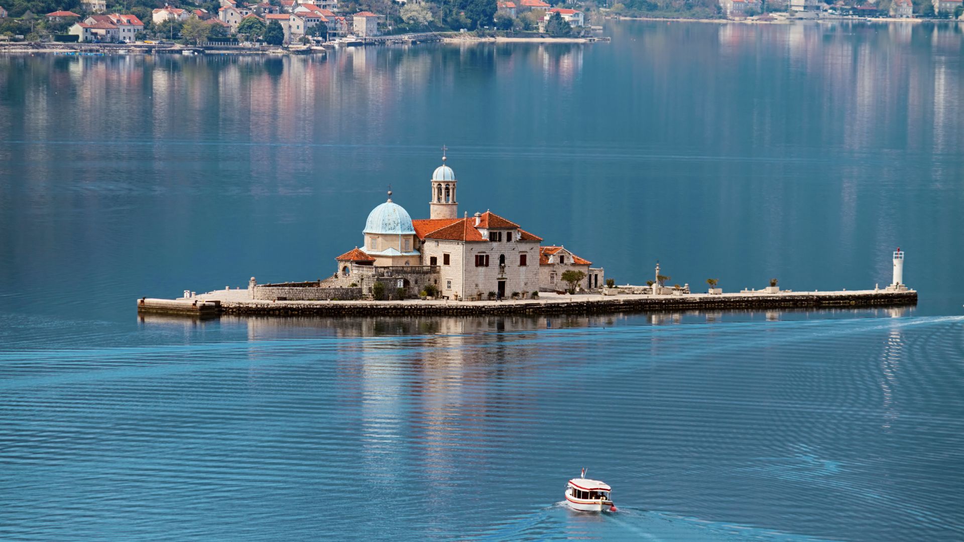 Our Lady of the Rocks — the artificial island built over two hundred years from sunken-ship ballast, the baroque church and museum on top of it. The cleanest tender-ashore stop in the inner bay.