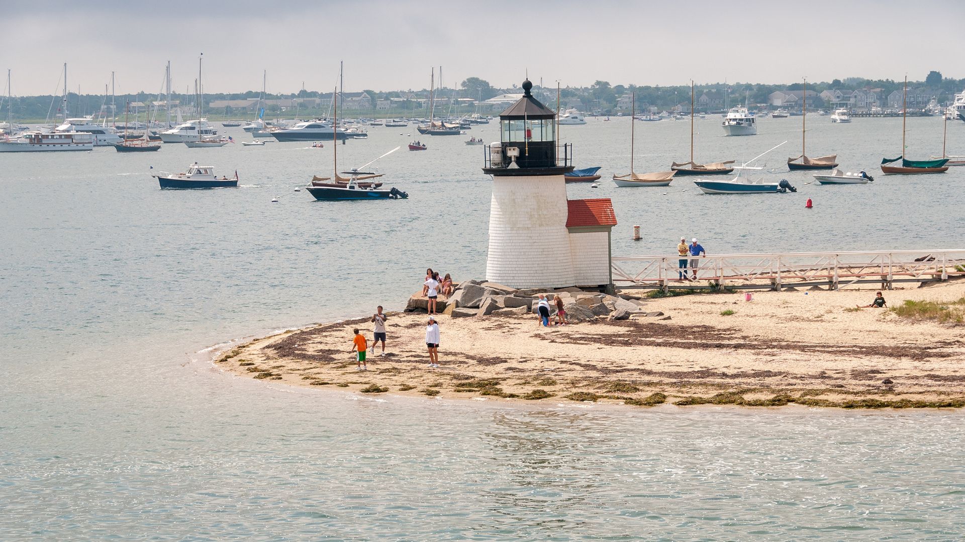 Rounding Brant Point — the small light at the harbor mouth is the arrival every Nantucket summer starts with.