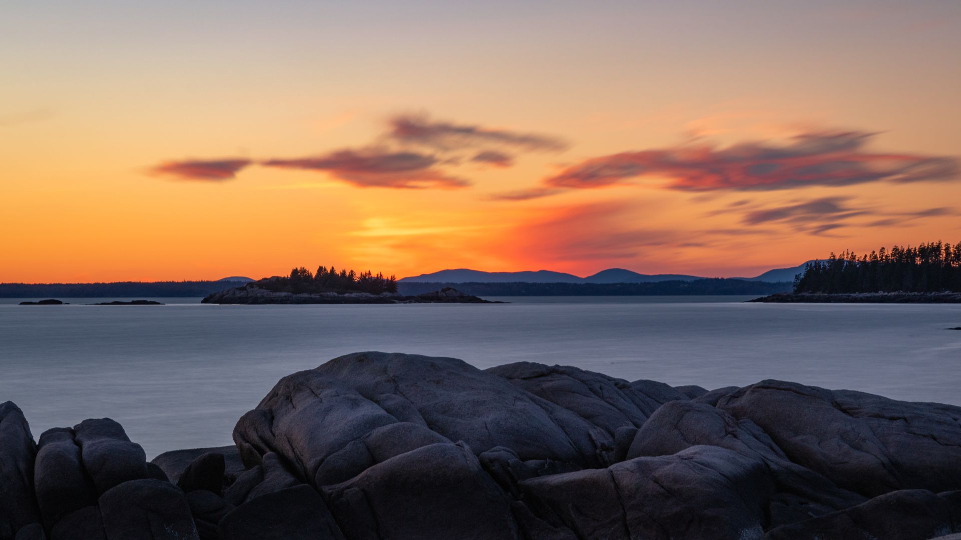 Sunset over granite ledges and spruce islands on Penobscot Bay, Maine