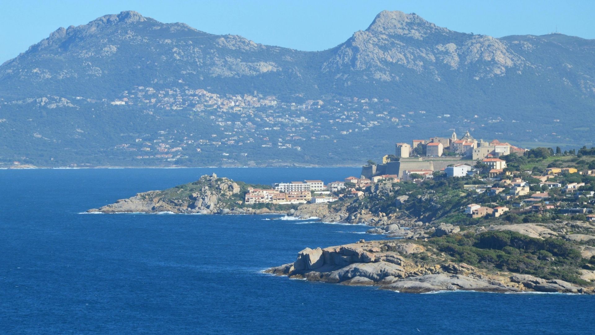 Calvi's Genoese citadel rising above the marina, with the five-mile beach and snow-capped mountains in the distance.