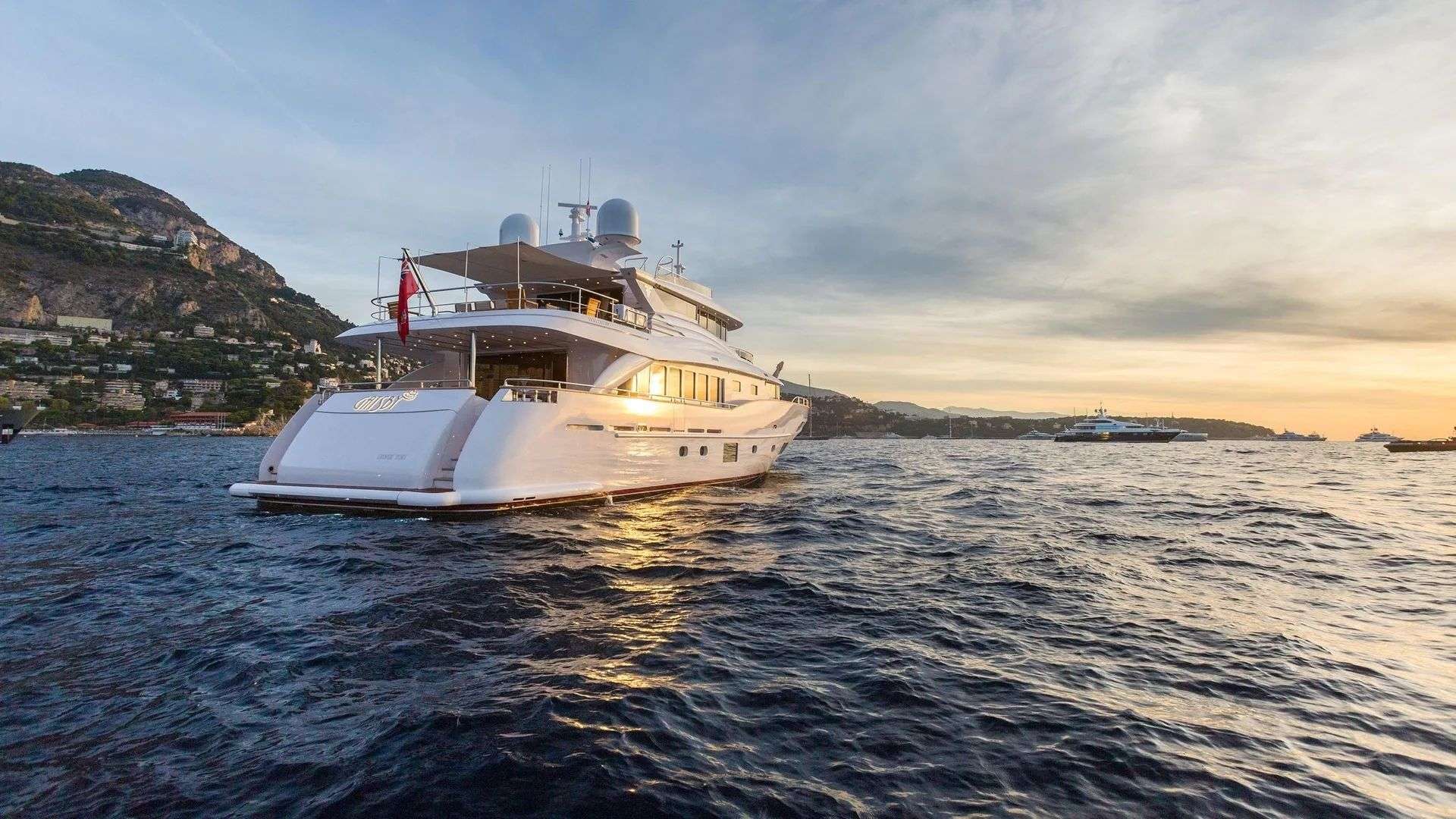 Sundowner on the deck of a crewed yacht at anchor in the Mediterranean