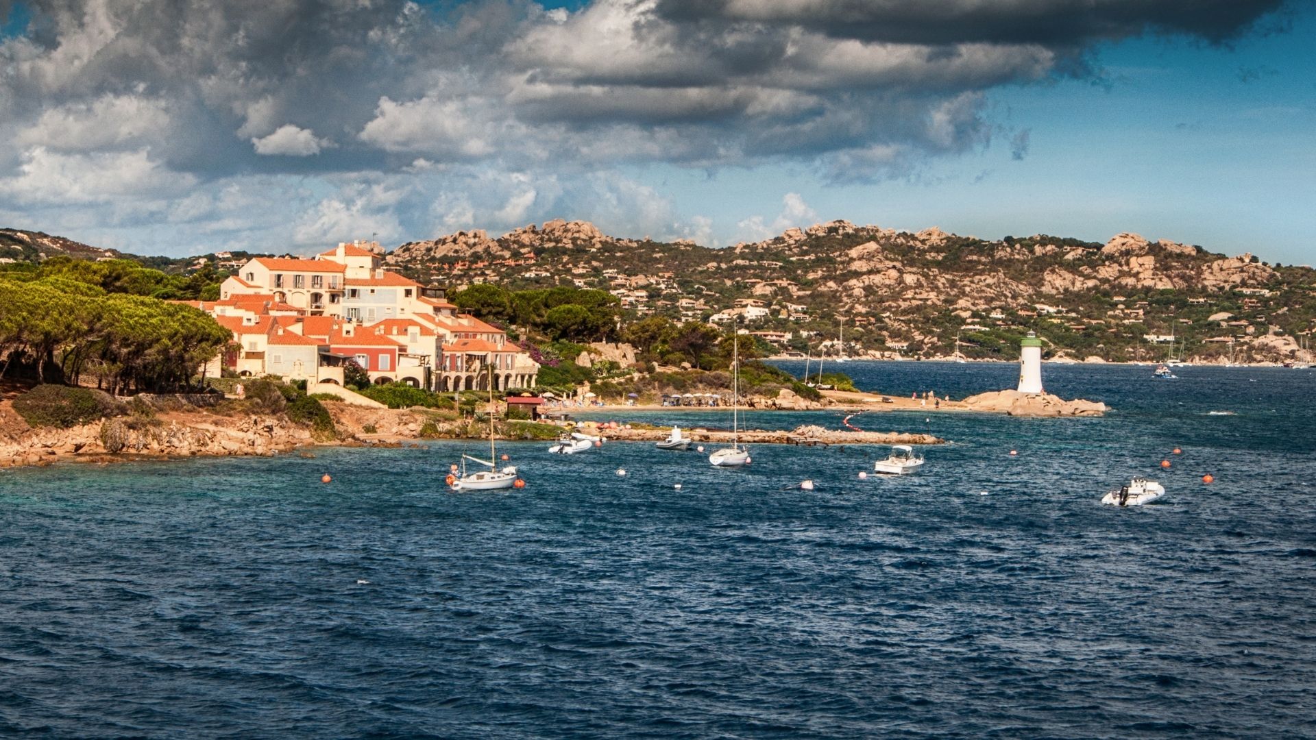 Porto Rafael — a quieter Costa Smeralda village built around a small harbor. The lunch crowd is local, the architecture restrained, and the price points lower than Porto Cervo.