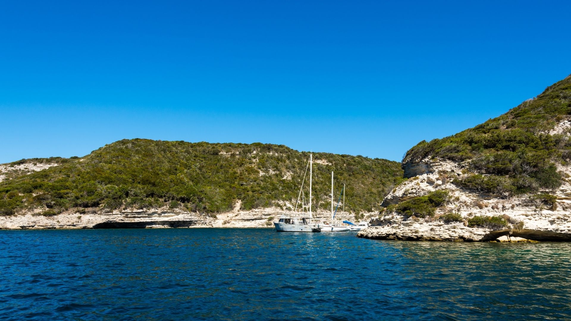 Crewed sailing catamaran under canvas in the Tyrrhenian Sea between Sardinia and Corsica