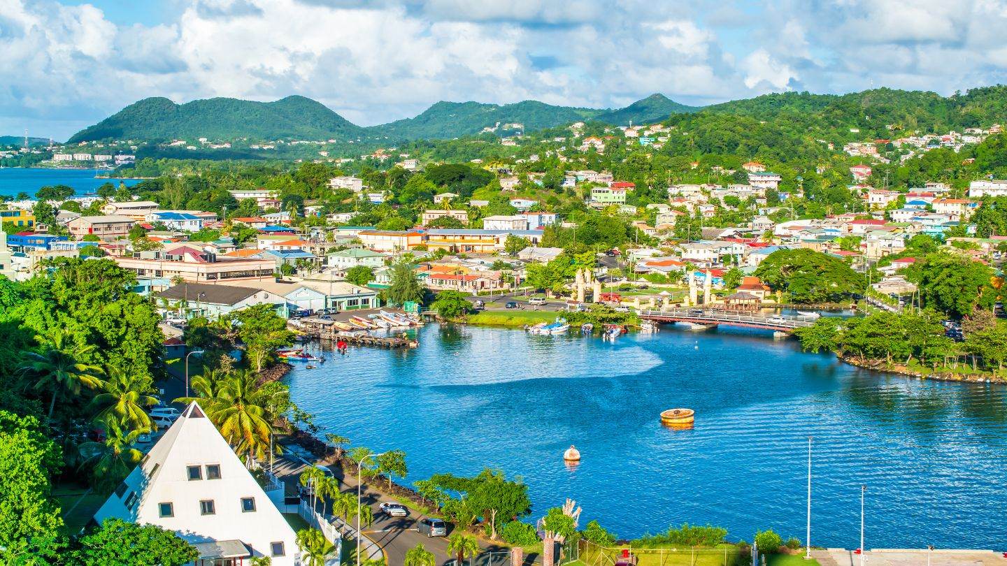 Aerial of Castries and its harbor lagoon with green hills behind