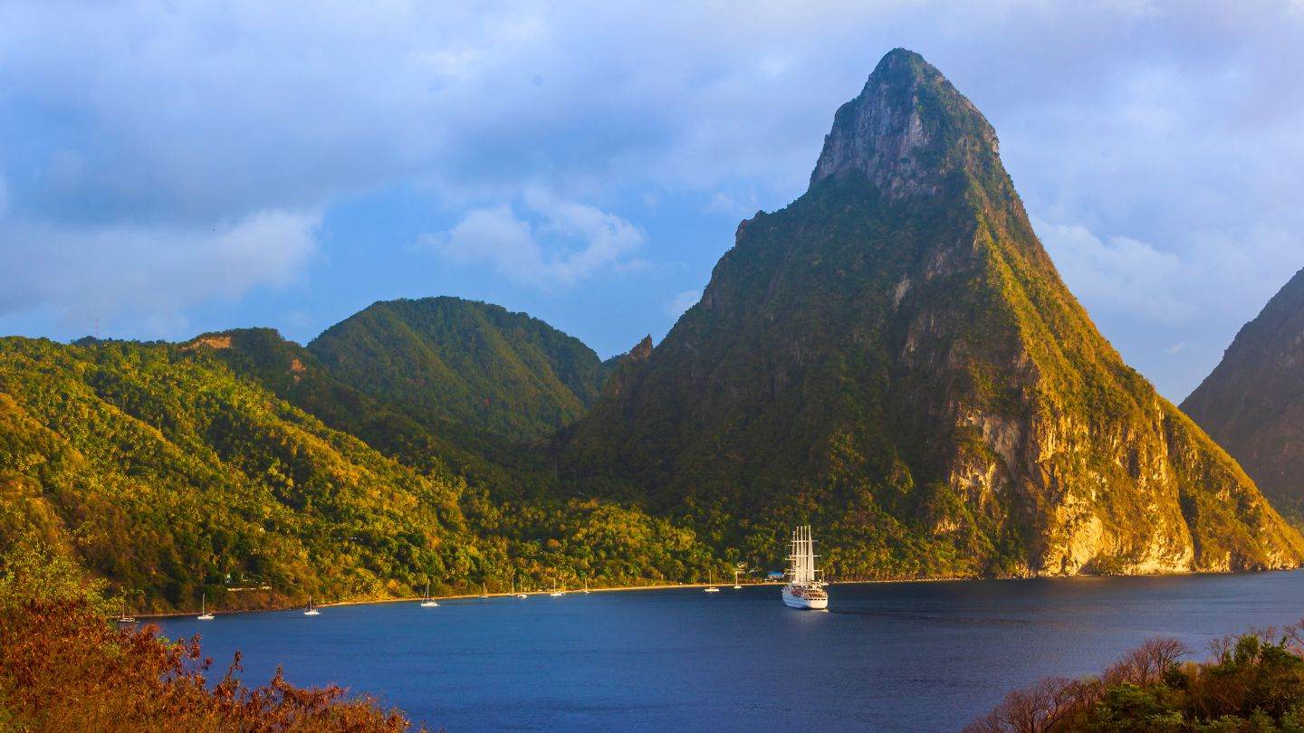 Golden hour at the foot of Petit Piton — the mooring field the whole week is built around.