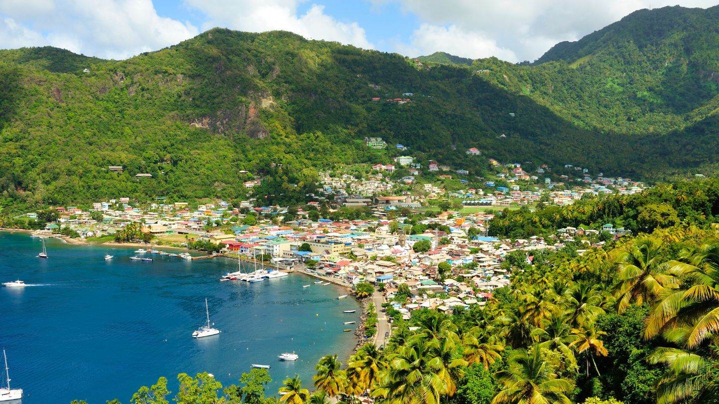 Soufrière on its bay — the old French capital at the foot of the peaks, tender distance from the moorings.