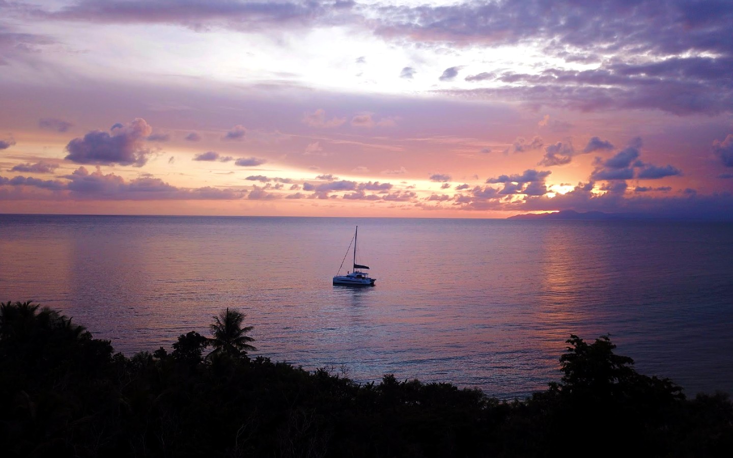 Green Beach faces west across the channel to the Puerto Rico mainland—the silhouette of El Yunque rainforest catches the sun on the way down. Best sunset on the route.