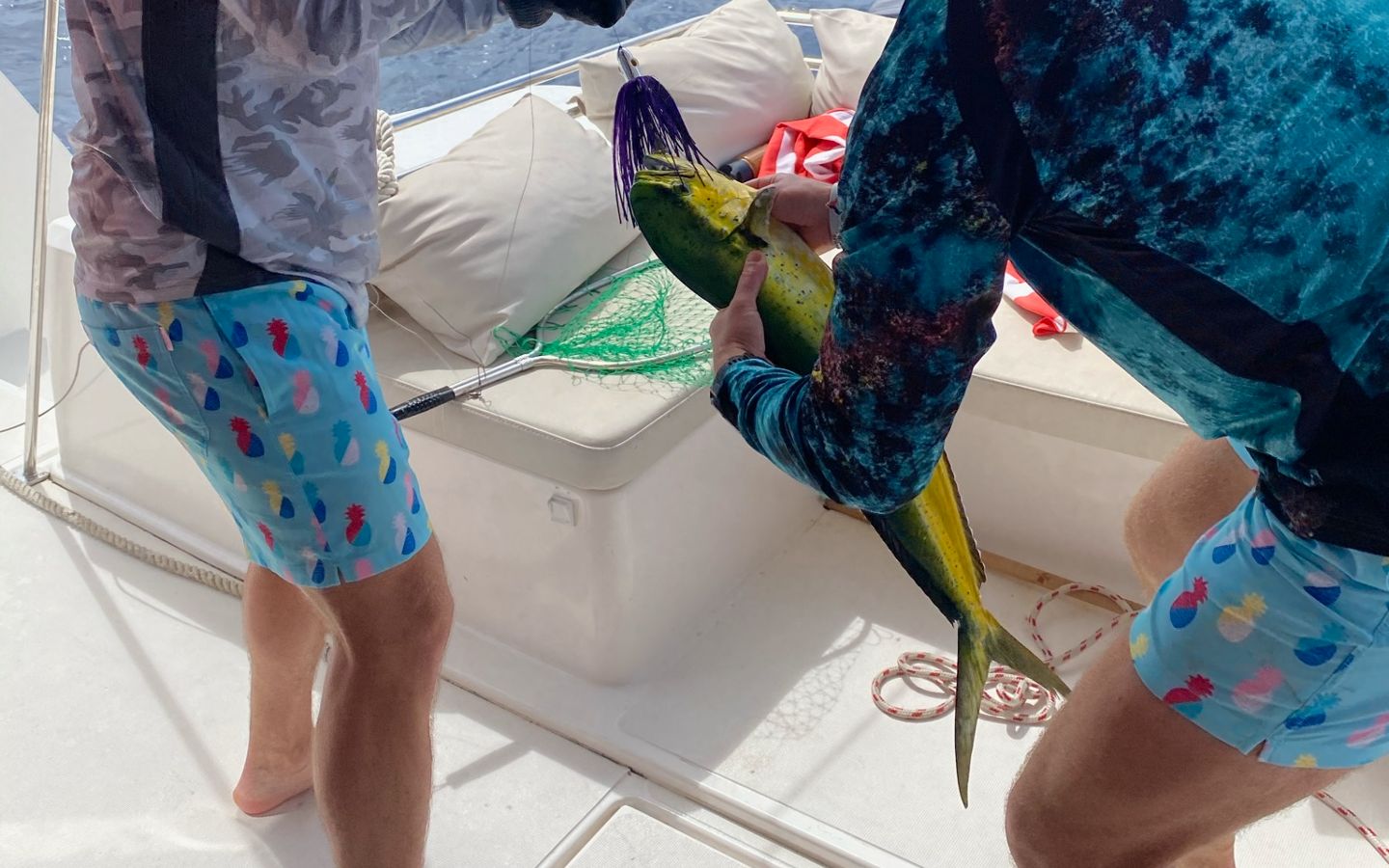 Two anglers handling a freshly caught mahi-mahi on the aft deck off Vieques