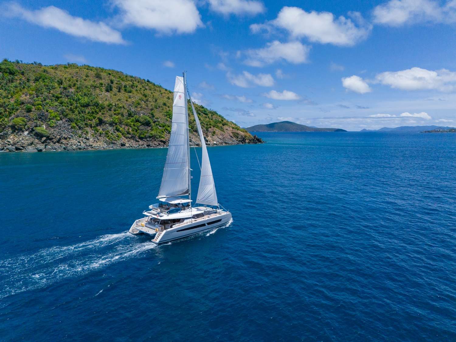 Crewed sailing catamaran under full canvas crossing Vieques Sound
