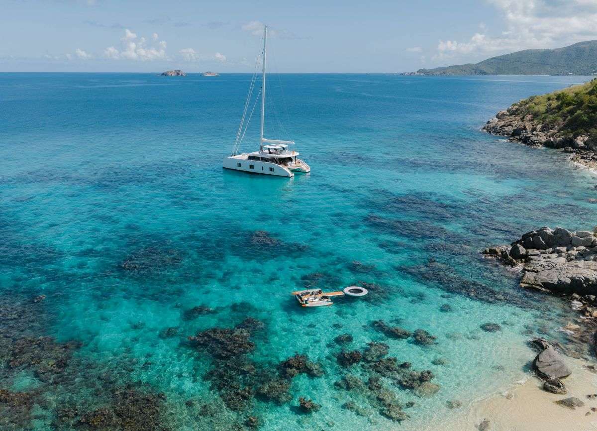 Crewed catamaran anchored in a secluded US Virgin Islands cove with water toys deployed