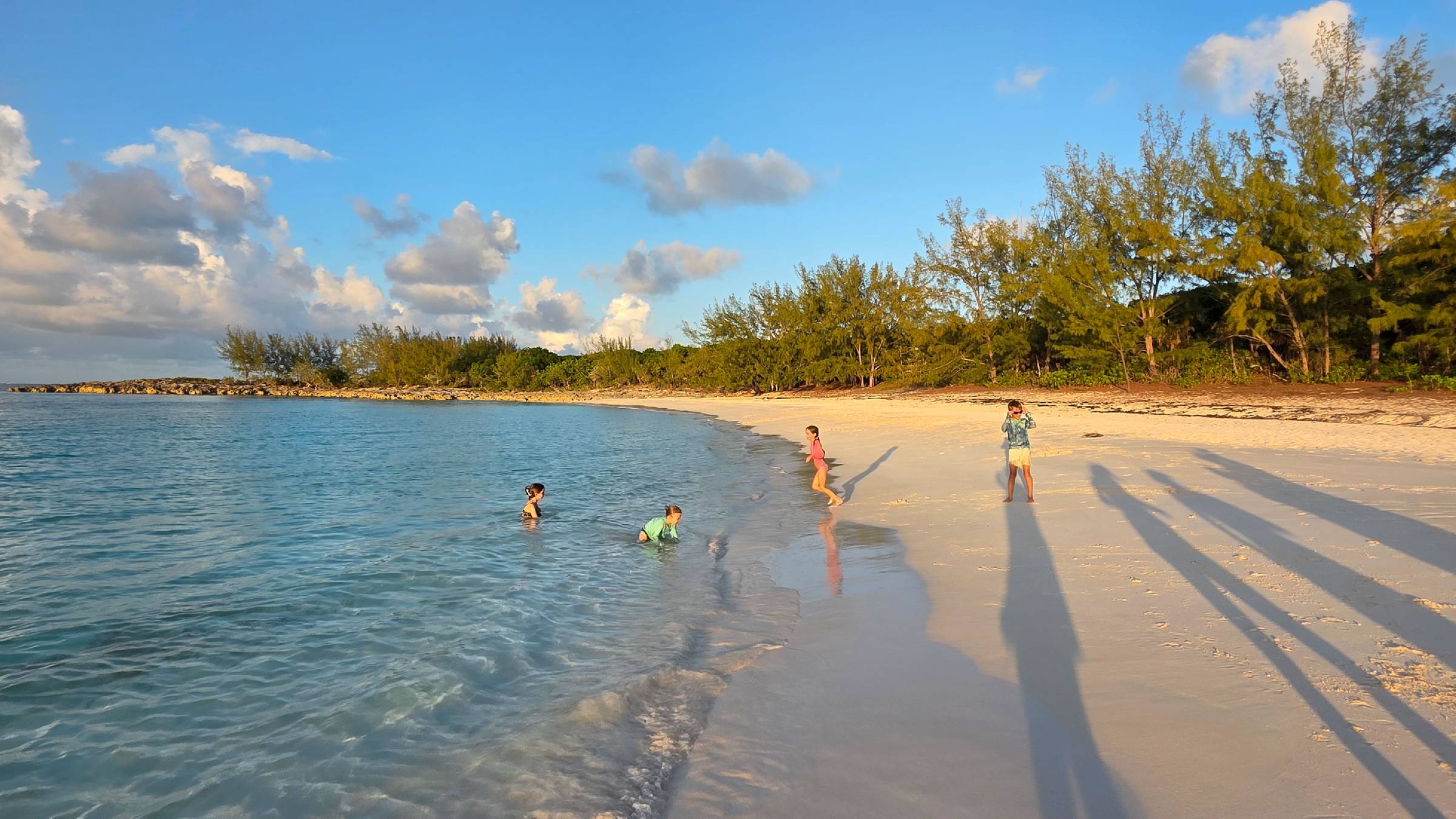 Kids playing on a secluded Caribbean beach at sunset on a family yacht charter